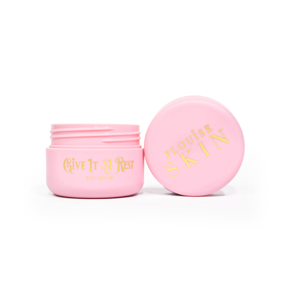Un pot rose ouvert de crème pour les yeux P.Louise Give It A Rest montrant le couvercle et le pot de côté avec la marque et le nom du produit sur le pot en écriture dorée.
