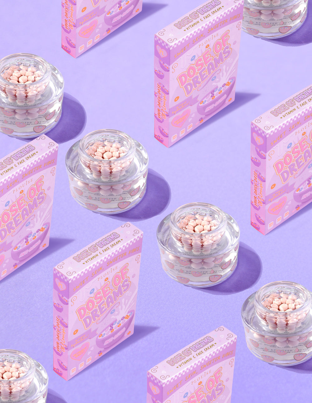 Contenants transparents de crème pour le visage P.Louise DOse of Dreams Viatmin C Capsule contenant une capsule rose entourée de boîtes de céréales roses sur fond violet