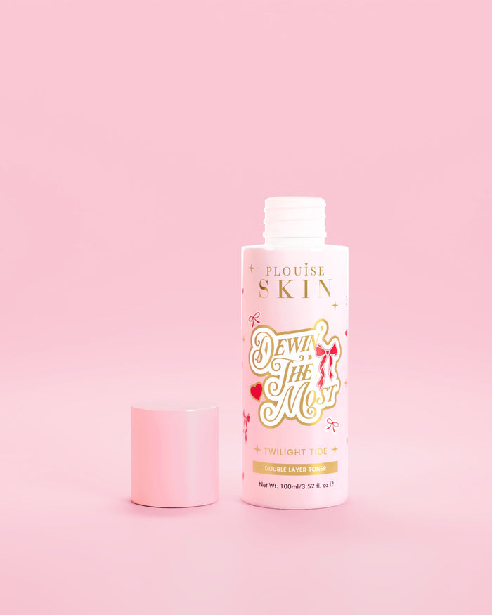 Bouteille rose de toner double couche P.Louise Dewin The MOst avec des motifs d'arcs rouges sur fond rose 