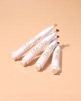 Une image de quatre masques à lèvres teintés P.Louise Softie Swipe au parfum de gâteau à la noix de coco empilés les uns contre les autres sur un fond beige