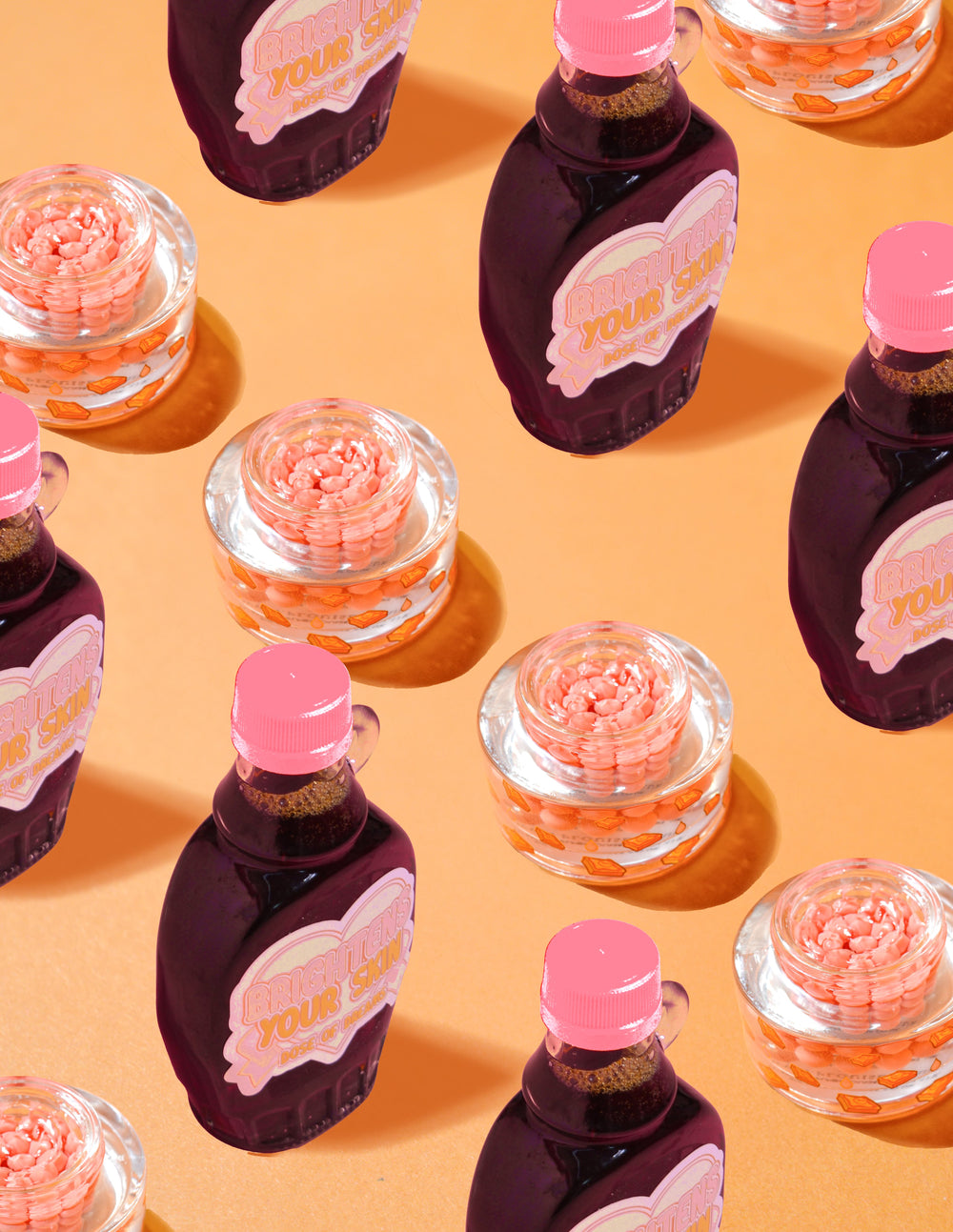 Récipients transparents de crème capsule de vitamine C P.Louise Dose of Dreams contenant des capsules orange entourées de bouteilles de sirop violettes et roses sur fond orange