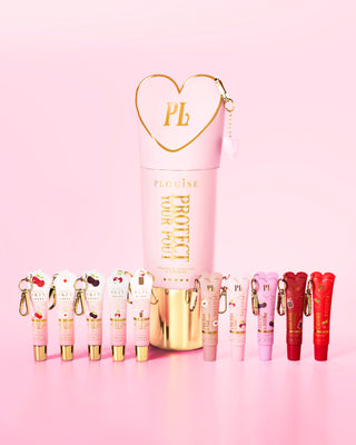 Set of pink and red cherry-scented lip conditioners with a prominent pink and gold protect your pout bottle in the center on a pink background.
