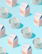 Récipients transparents de crème capsule de vitamine C P.Louise Dose of Dreams avec une capsule bleue à l'intérieur entourée de cartons de lait