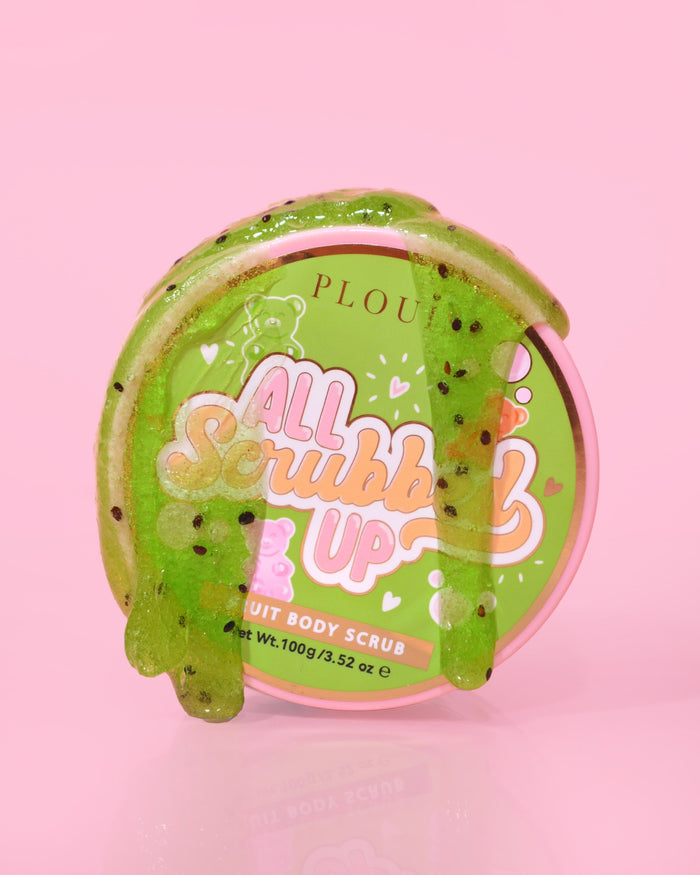 Un contenant de P.Louise All Scrubbed Up Body Scrub portant l'étiquette « Candy Bears » sur fond rose, le produit apparaissant sous la forme d'un gel vert.