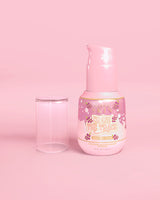 Flacon rose de sérum correcteur de taches brunes P. Louise Erase The Trace avec le couvercle retiré sur fond rose