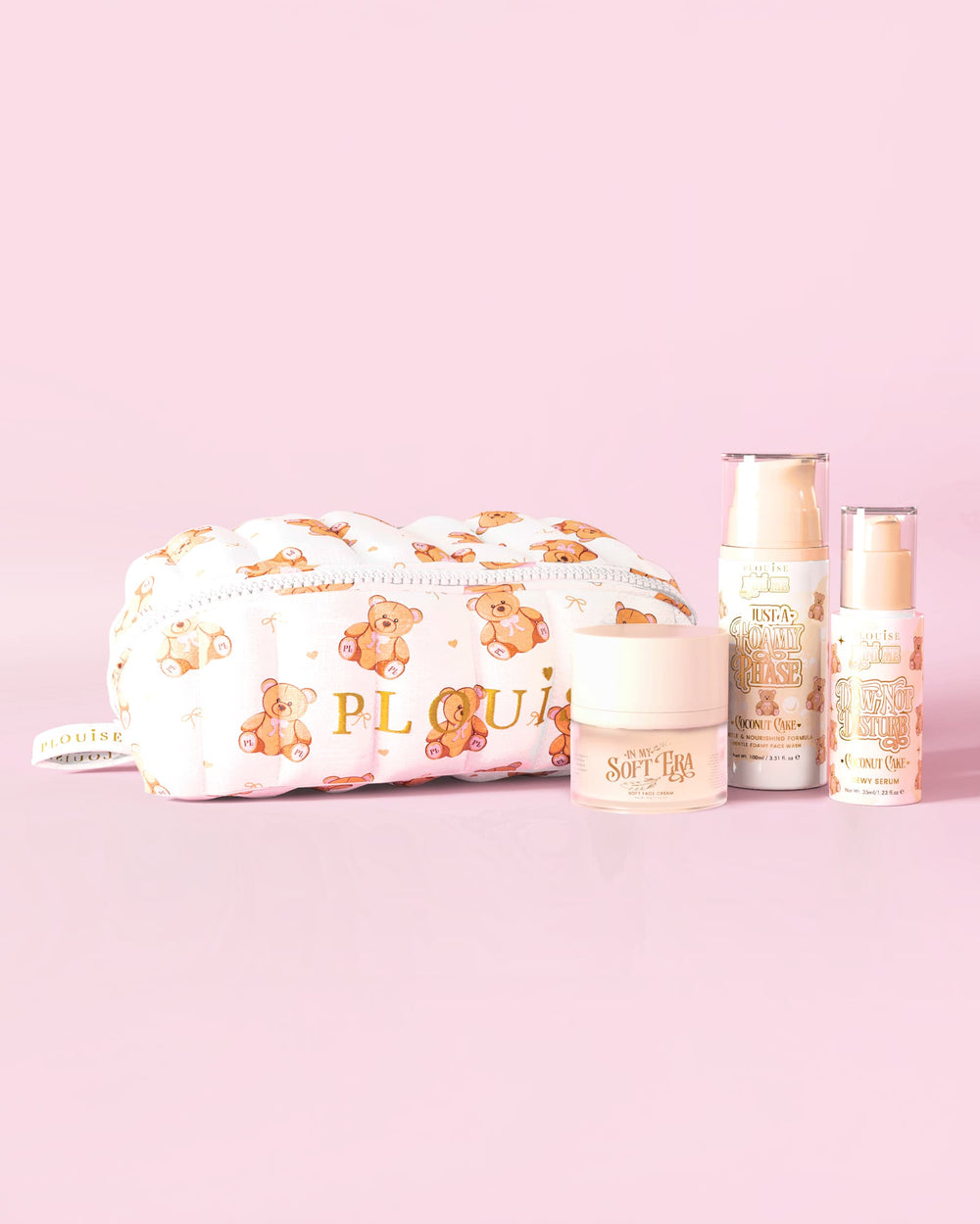 Une image du kit de démarrage de soins de la peau P.Louise Softest Touch avec une trousse de soins de la peau et de maquillage en forme d'ours en peluche en gros caractères et 3 produits de soins de la peau sur fond rose