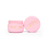 Un pot rose ouvert de crème pour les yeux P.Louise Give It A Rest montrant le couvercle et le pot de côté avec la marque et le nom du produit sur le pot en écriture dorée.