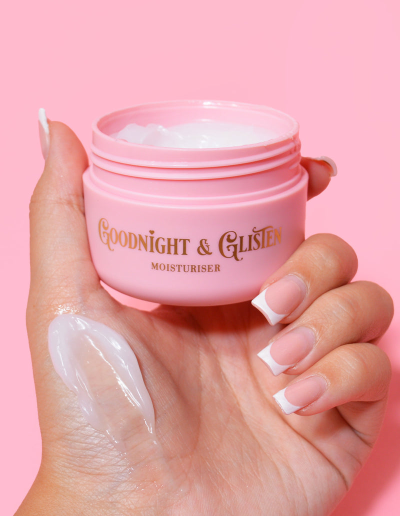 Une main tenant un pot rose de gel hydratant P.Louise Goodnight & Glisten avec un peu de crème hydratante visible sur le .and